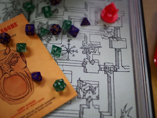 Polyhedral dice spread out over a map and book